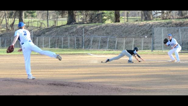 Anna-Jonesboro pitcher Kyle Jerrell throws the ball to first baseman Ethan Ames during the third inning of a high school baseball game which was played Thursday, March 17. A-J was hosting Carbondale in the game, which was played at Kiwanis Field at the Anna City Park. Carbondale’s Colby Boudet was diving back into first base on the play.