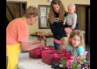 Anna-Jo Garden Club member Linda Karraker helped Maeve and Mia Kell pick out flowers for the pots they had painted during an annual Paint and Plant program Friday afternoon, May 12, at Stinson Memorial Library in Anna. Photo by Amber Skelton.